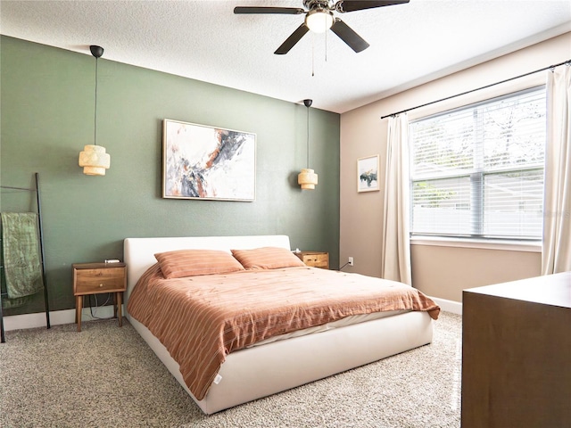 bedroom with a textured ceiling, carpet, and ceiling fan