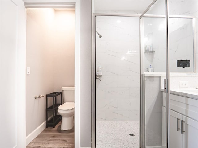 bathroom featuring vanity, hardwood / wood-style flooring, toilet, and an enclosed shower