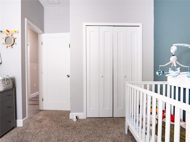 bedroom with a closet, carpet floors, and a crib