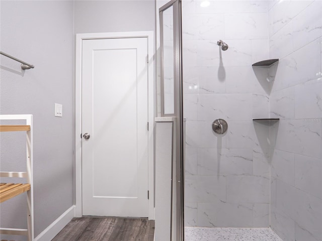 bathroom featuring a tile shower and hardwood / wood-style flooring