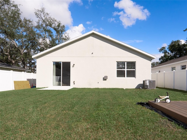 back of property featuring a wooden deck, a yard, and central air condition unit