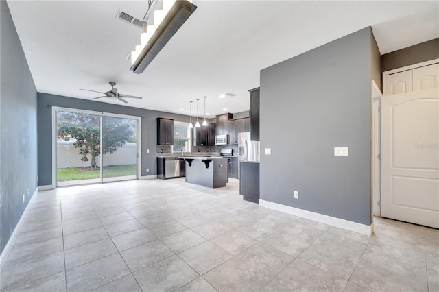 unfurnished living room featuring ceiling fan and light tile patterned flooring