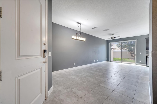 unfurnished room with a textured ceiling, ceiling fan, and light tile patterned flooring