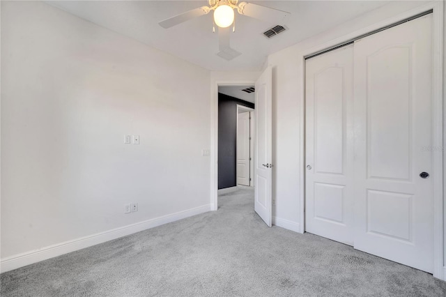 unfurnished bedroom featuring ceiling fan, light carpet, and a closet