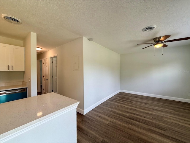 kitchen featuring white cabinetry, dishwashing machine, dark wood-type flooring, and a textured ceiling