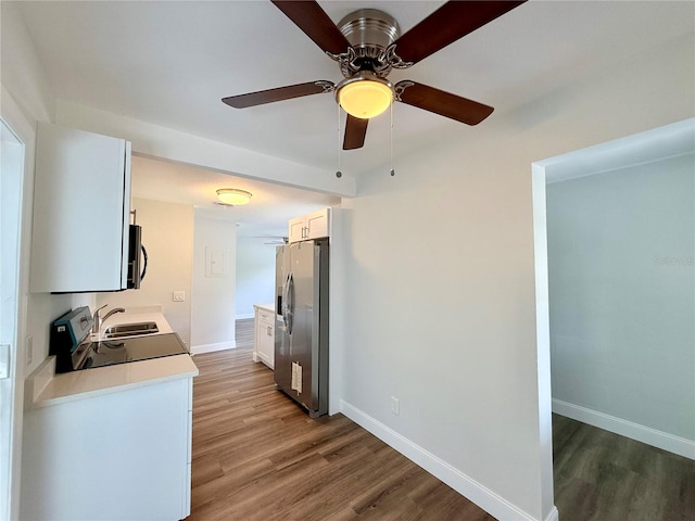 kitchen featuring white cabinetry, stainless steel appliances, wood-type flooring, and ceiling fan