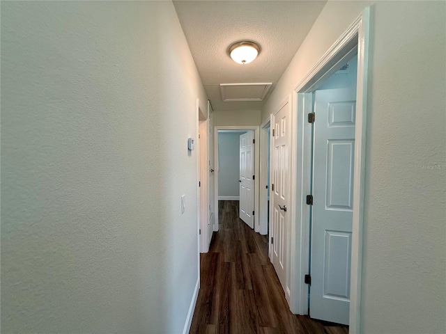 hallway featuring a textured ceiling and dark wood-type flooring