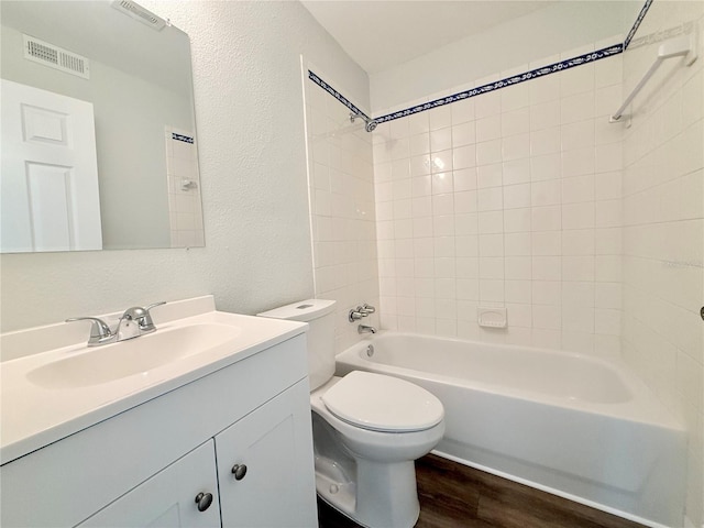 full bathroom featuring toilet, tiled shower / bath, hardwood / wood-style flooring, and vanity