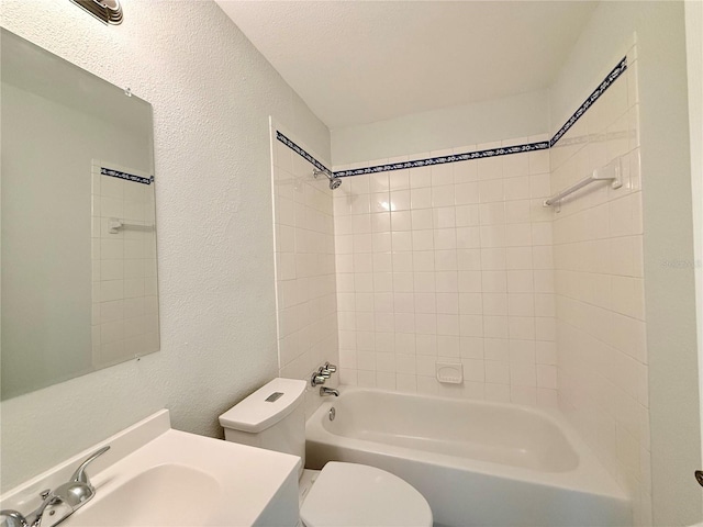 full bathroom featuring vanity, tiled shower / bath combo, a textured ceiling, and toilet