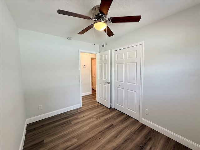 unfurnished bedroom featuring dark hardwood / wood-style flooring, a closet, and ceiling fan