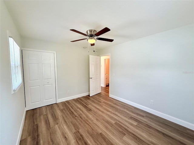 unfurnished bedroom featuring a closet, hardwood / wood-style flooring, and ceiling fan