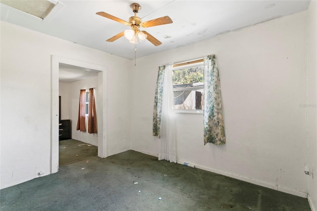 empty room with dark carpet and ceiling fan