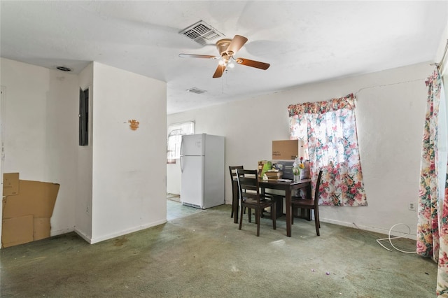 dining area featuring dark carpet and ceiling fan