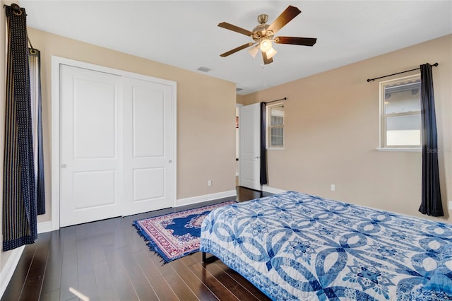 bedroom with dark wood-type flooring, a closet, and ceiling fan