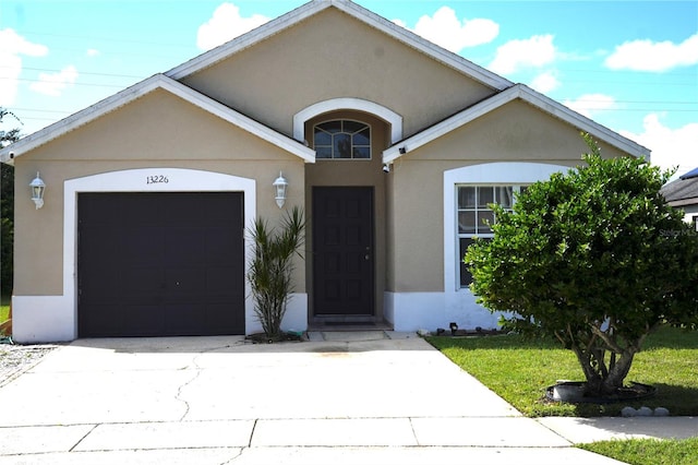 single story home with a front yard and a garage