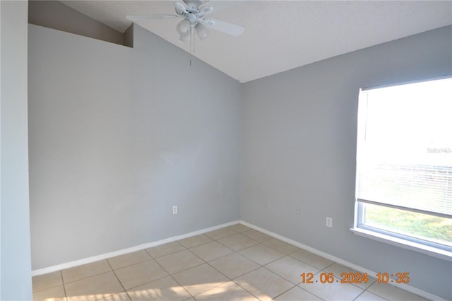 tiled spare room with ceiling fan, lofted ceiling, and a textured ceiling