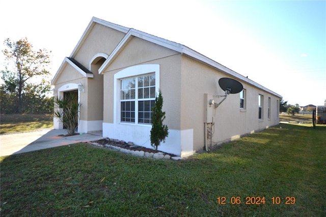 view of side of home featuring a garage and a yard