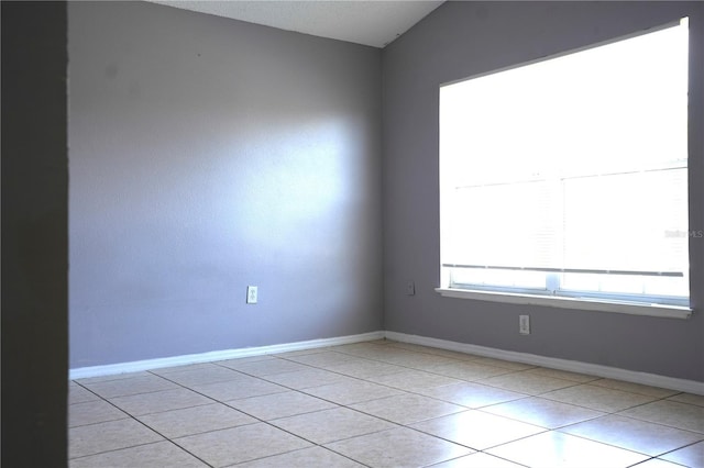 tiled empty room with vaulted ceiling