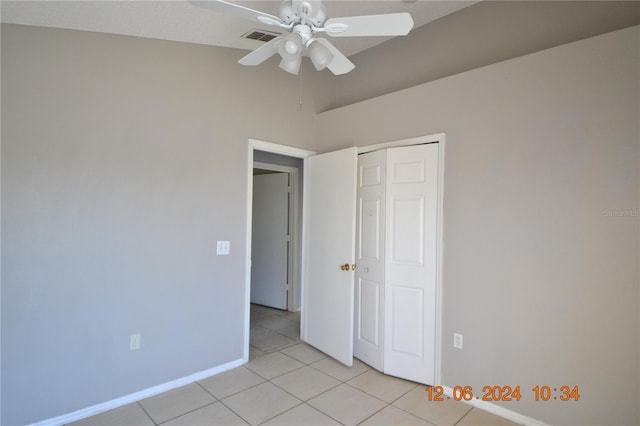 unfurnished bedroom with light tile patterned floors, a closet, and ceiling fan