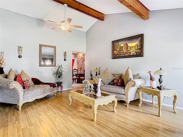 living room with ceiling fan, hardwood / wood-style floors, and vaulted ceiling with beams