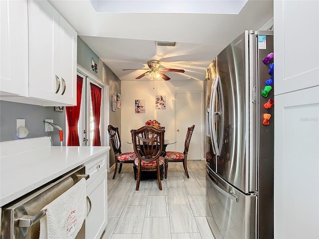 kitchen featuring ceiling fan, appliances with stainless steel finishes, and white cabinetry