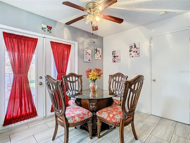 dining space featuring ceiling fan and a textured ceiling