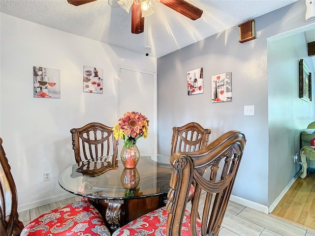 dining space with ceiling fan and a textured ceiling