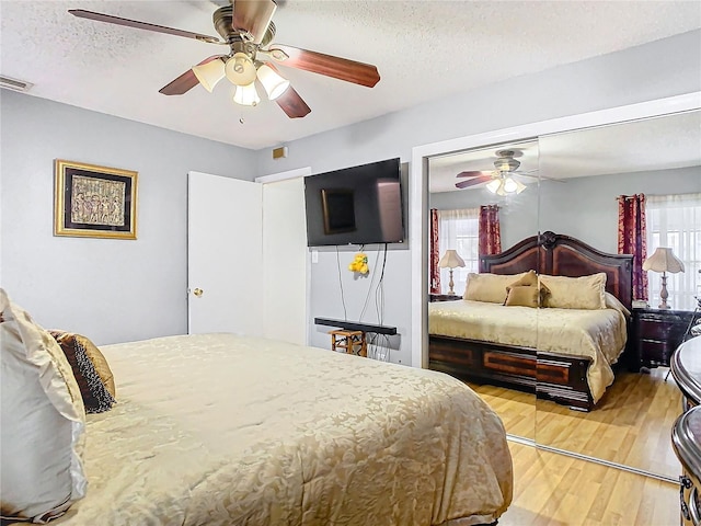 bedroom featuring a textured ceiling, ceiling fan, and wood-type flooring