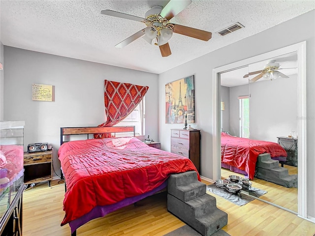 bedroom featuring ceiling fan, a textured ceiling, and light hardwood / wood-style flooring