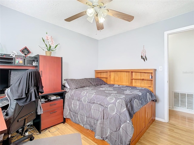 bedroom with ceiling fan, a textured ceiling, and light hardwood / wood-style flooring