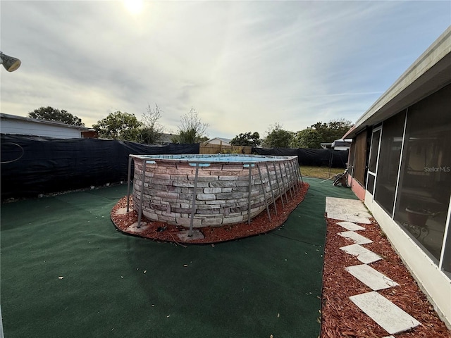 view of patio / terrace featuring a fenced in pool and a sunroom