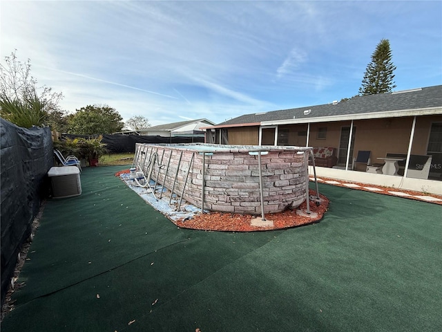 view of swimming pool featuring a sunroom, area for grilling, and a lawn