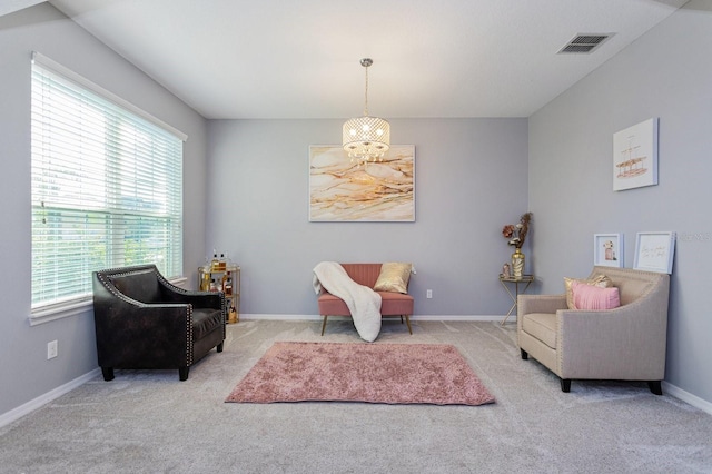 living area featuring light colored carpet and an inviting chandelier