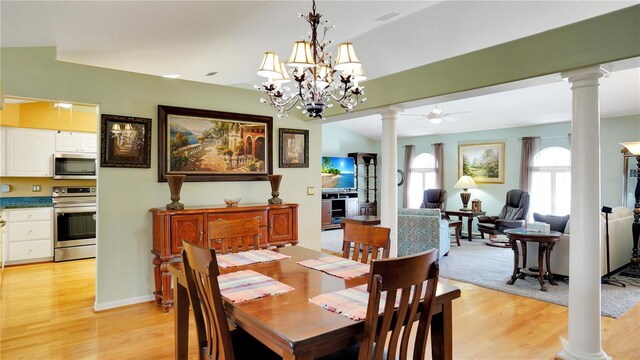 dining room featuring ceiling fan, light wood finished floors, and ornate columns