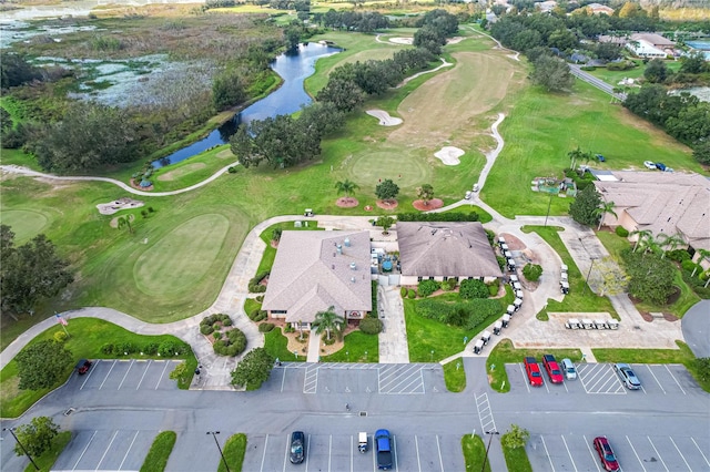 birds eye view of property with view of golf course and a water view