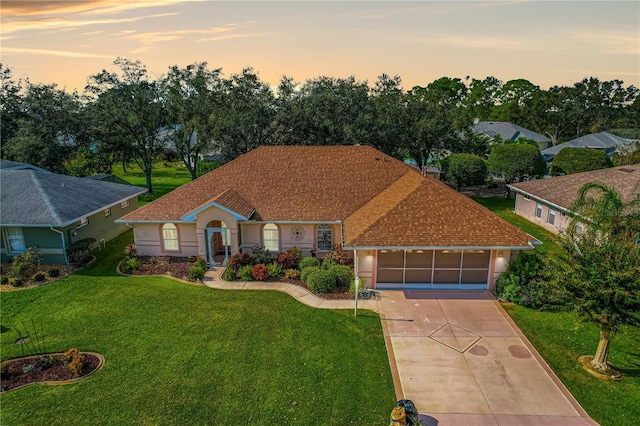 view of front facade with a garage and a lawn