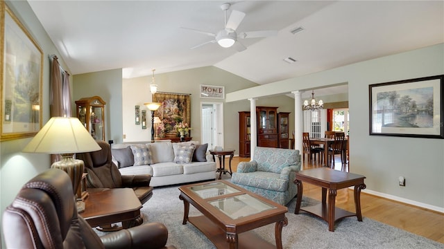 living room featuring decorative columns, visible vents, vaulted ceiling, light wood-type flooring, and ceiling fan with notable chandelier