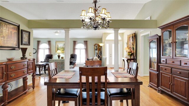 dining room featuring a chandelier, light wood-style floors, and ornate columns