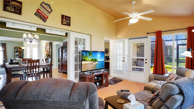 living room featuring a wealth of natural light, french doors, carpet, and ceiling fan with notable chandelier