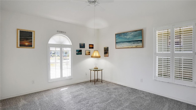 spare room featuring carpet floors, ceiling fan, and baseboards