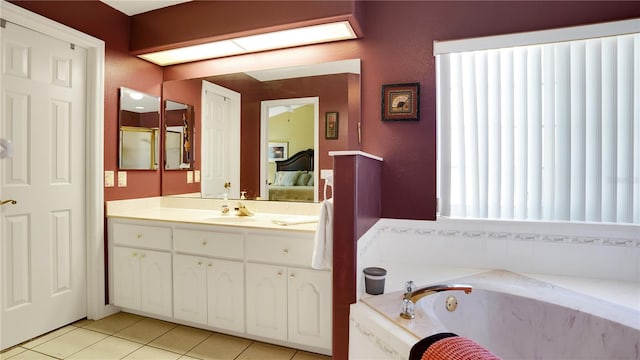 ensuite bathroom featuring a skylight, ensuite bathroom, tile patterned floors, a garden tub, and vanity