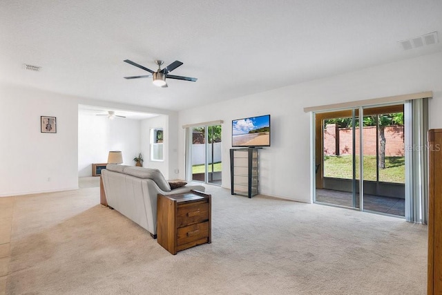 carpeted living room with ceiling fan