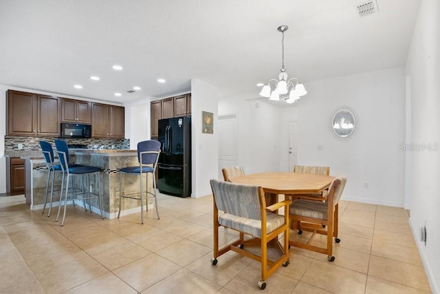 tiled dining room with a notable chandelier