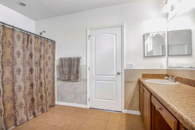 bathroom with vanity, a textured ceiling, a shower with curtain, and tile patterned floors