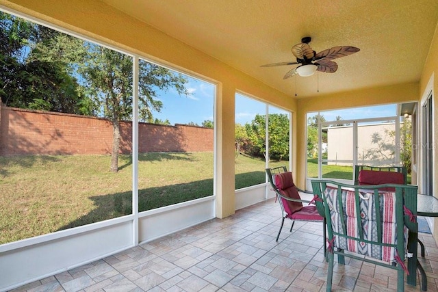 sunroom / solarium featuring a healthy amount of sunlight and ceiling fan