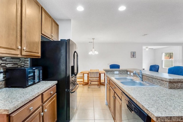 kitchen with black appliances, sink, an island with sink, light tile patterned flooring, and a textured ceiling