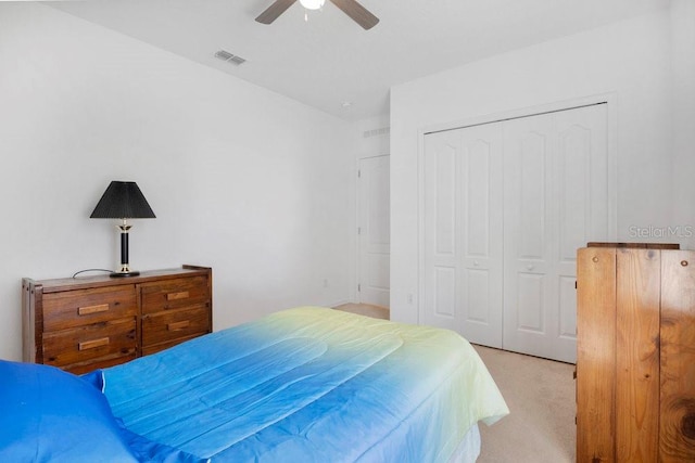 carpeted bedroom featuring a closet and ceiling fan