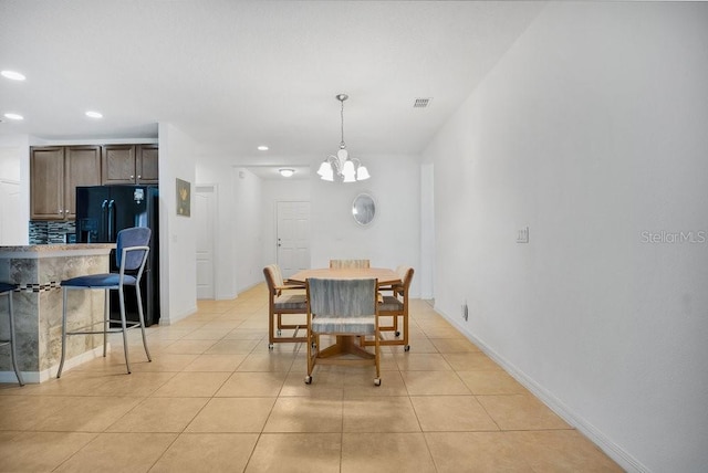 tiled dining area featuring an inviting chandelier