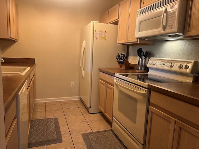 kitchen with light tile patterned flooring, sink, and white appliances