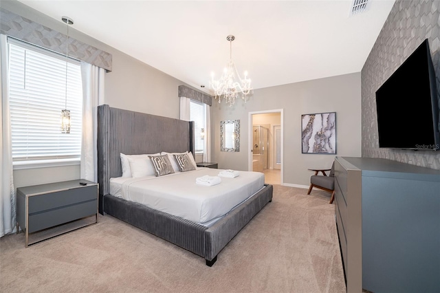 bedroom with light carpet, a chandelier, and connected bathroom